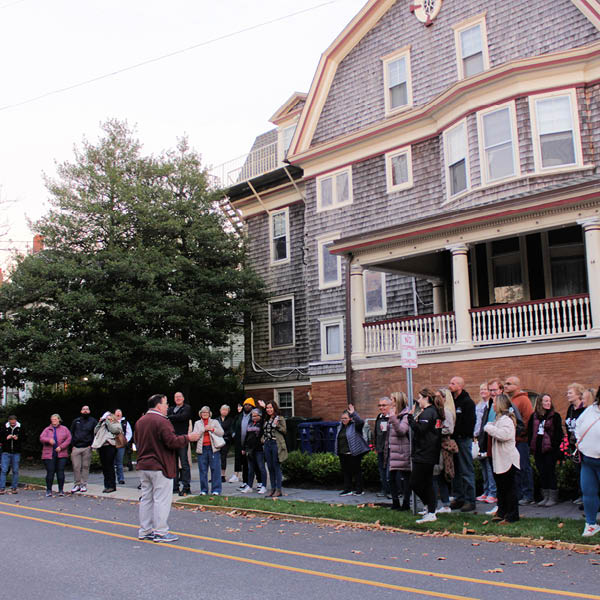 group of people on the sidewalk with a tour guide